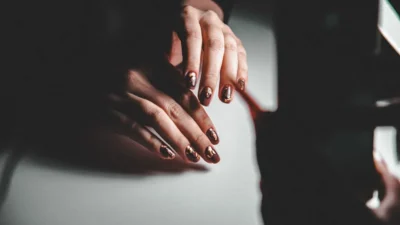 A woman's hands resting on a piano
