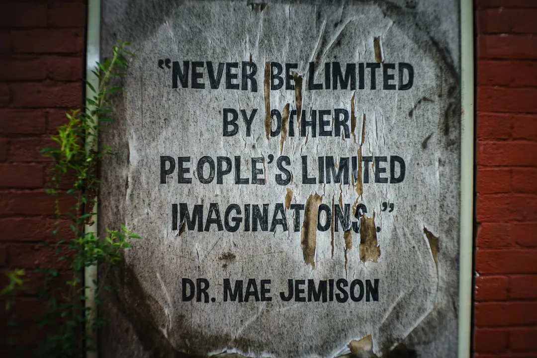 Quote on a weathered poster on brick wall.