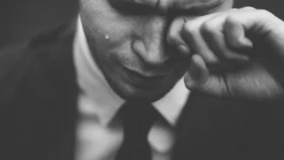 man wiping his tears