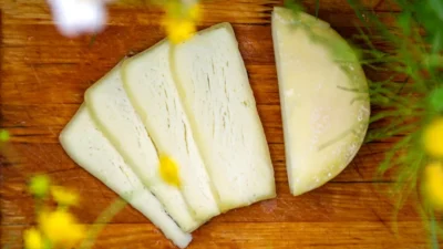 a wooden cutting board topped with sliced cheese