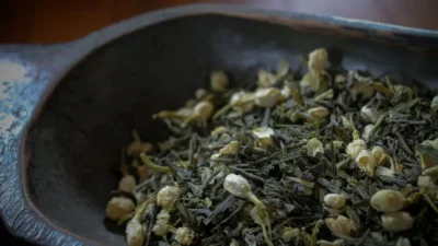 A bowl filled with green tea on top of a wooden table