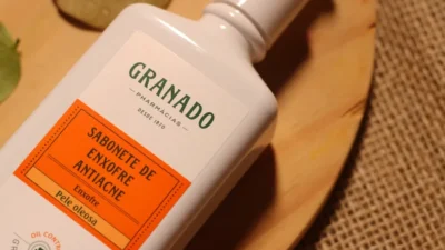 A bottle of lotion sitting on top of a wooden plate