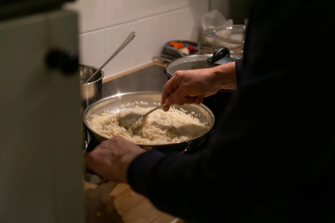 a person stirring a bowl of food on a stove