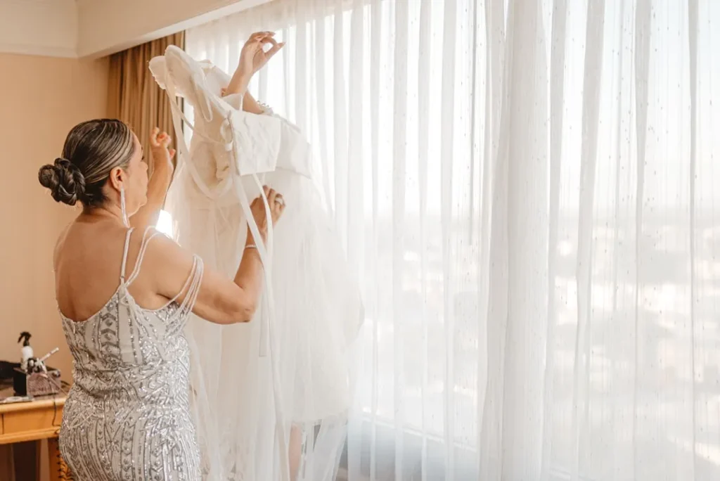 Woman holding a wedding dress by the window