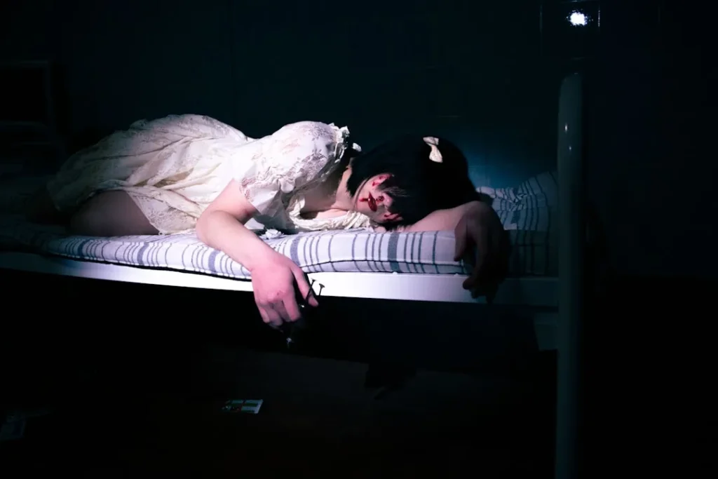 a woman laying on a bed in a dark room
