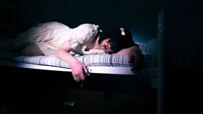 a woman laying on a bed in a dark room