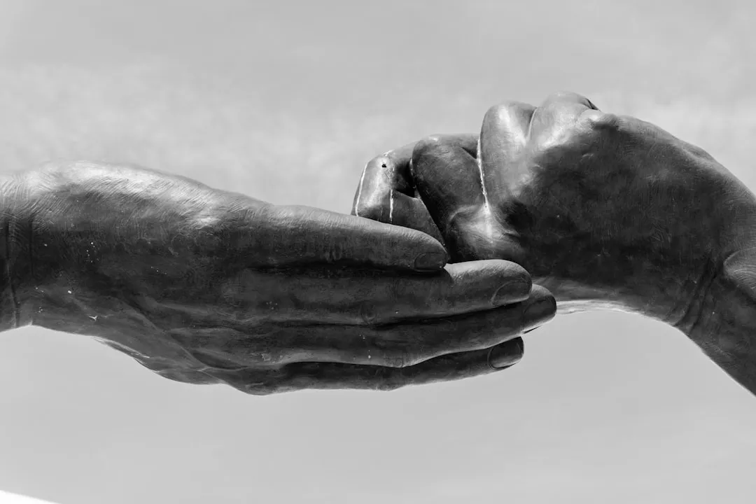 Two hands gently holding each other.