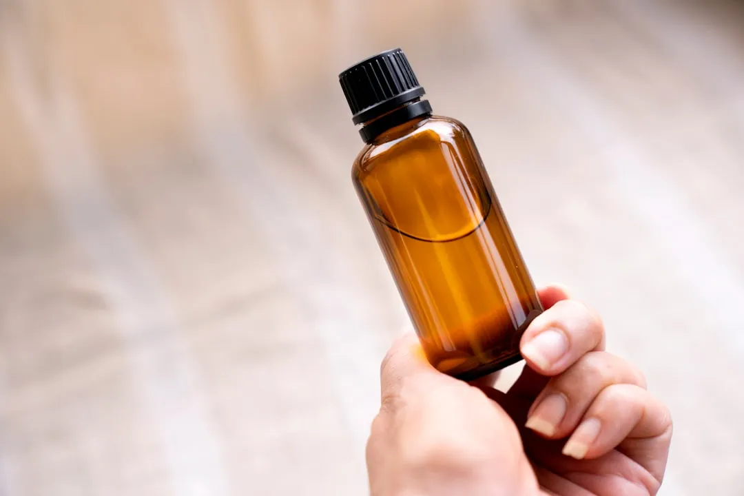 a person holding a bottle of essential oils
