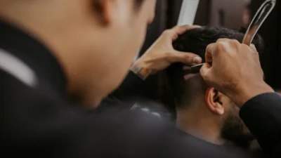 selective focus photography of person cutting hair of man