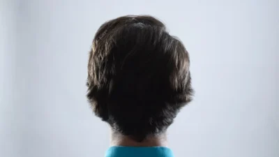 The back of a man's head in a blue shirt