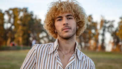a man with curly hair wearing a striped shirt