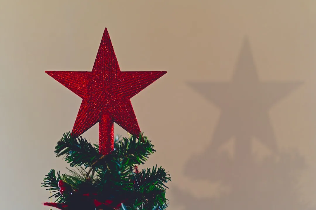 A red star on top of a christmas tree