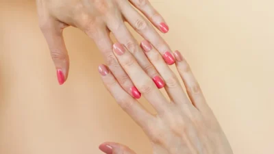 A woman's hands with pink manicures on them