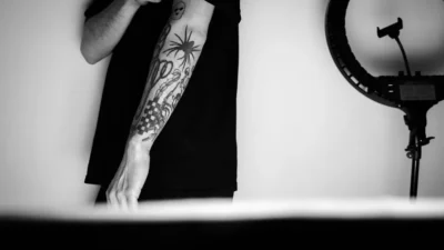 a man with a tattoo standing in front of a mirror