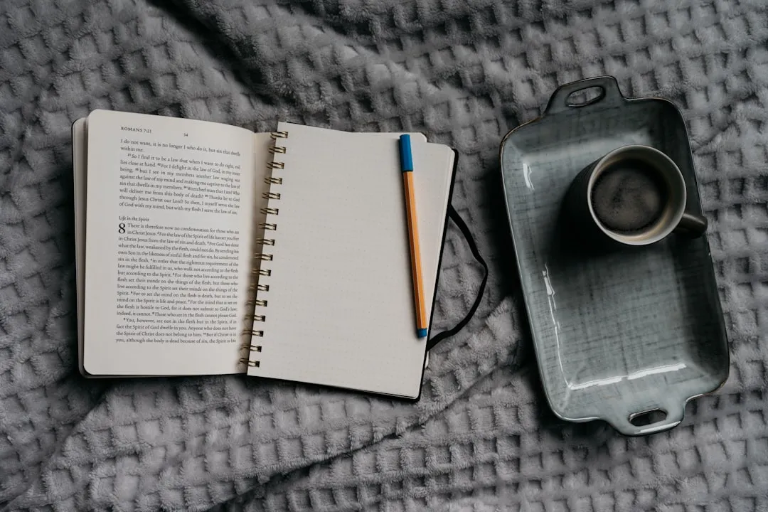 Coffee and journal on a bed.