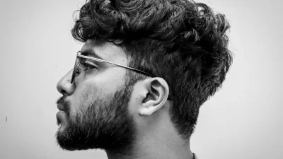 Man with glasses and curly hair in profile.
