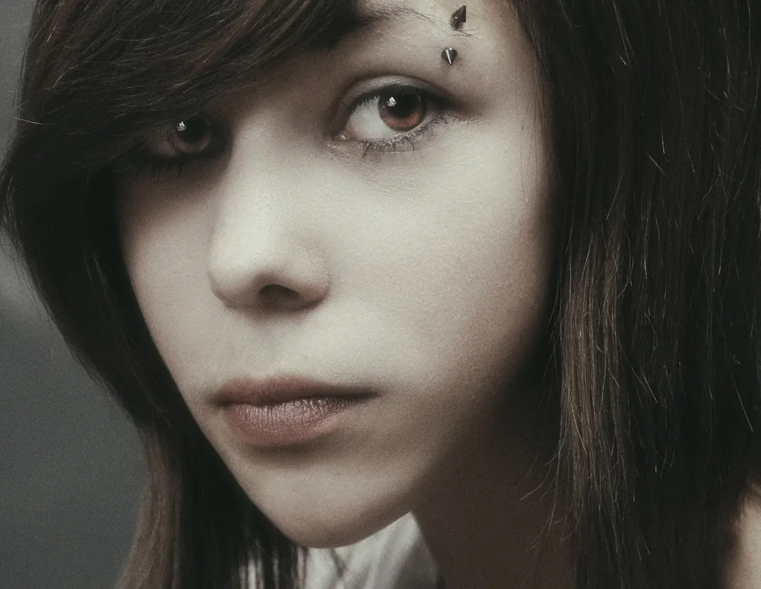 A young woman with dark hair gazes intently.