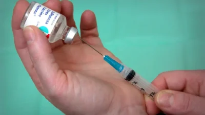 person holding syringe and vial