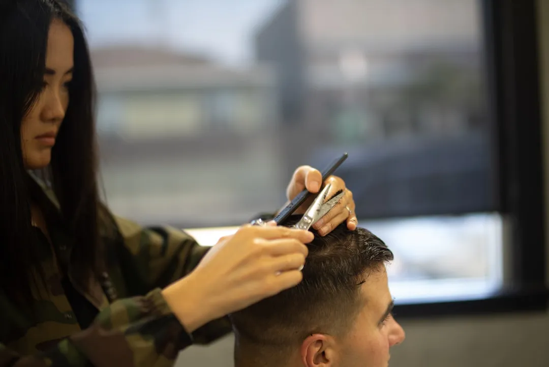 woman cutting mans hair close-up photography